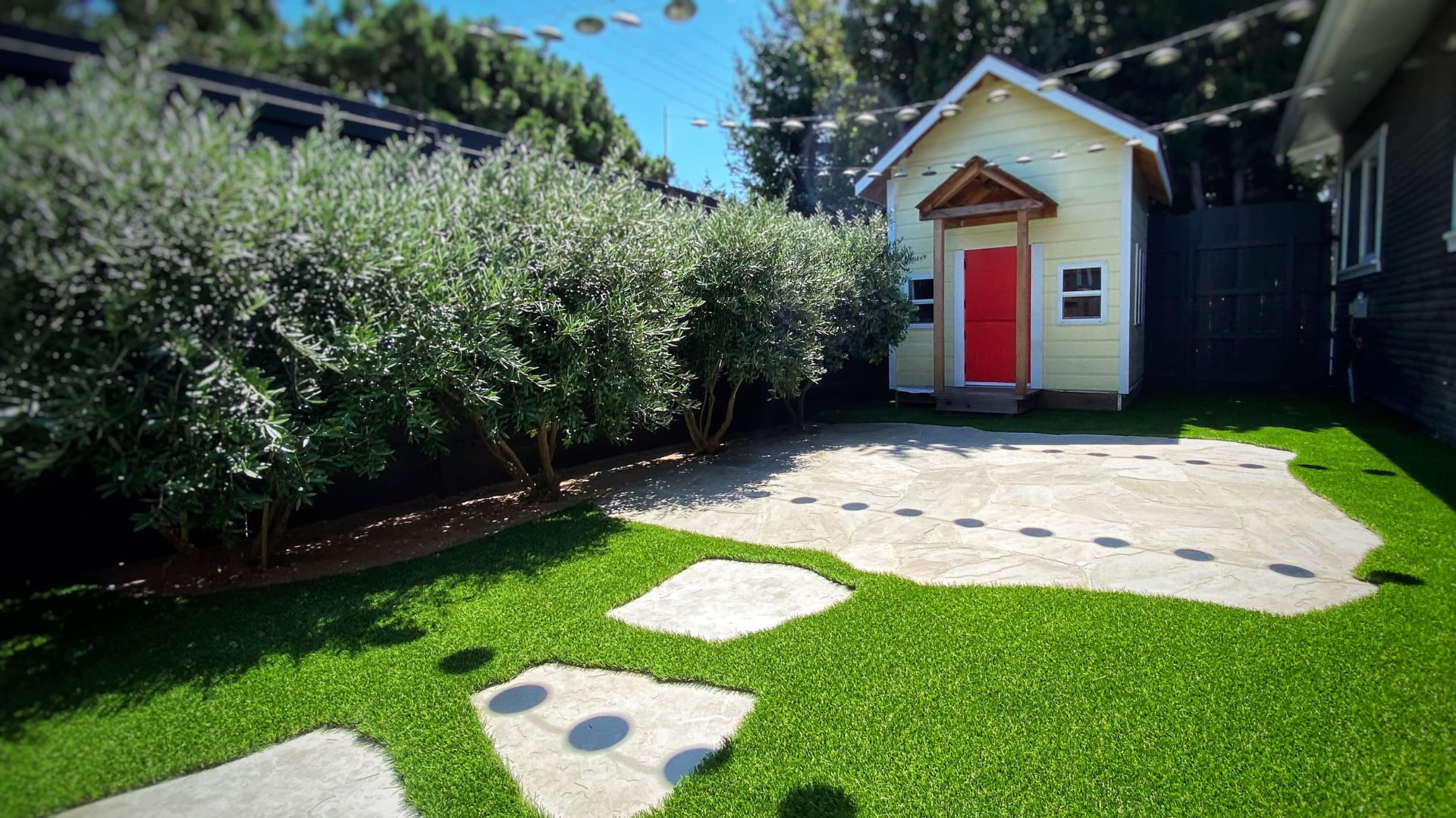 Artificial turf lawn with flagstone patio and playhouse