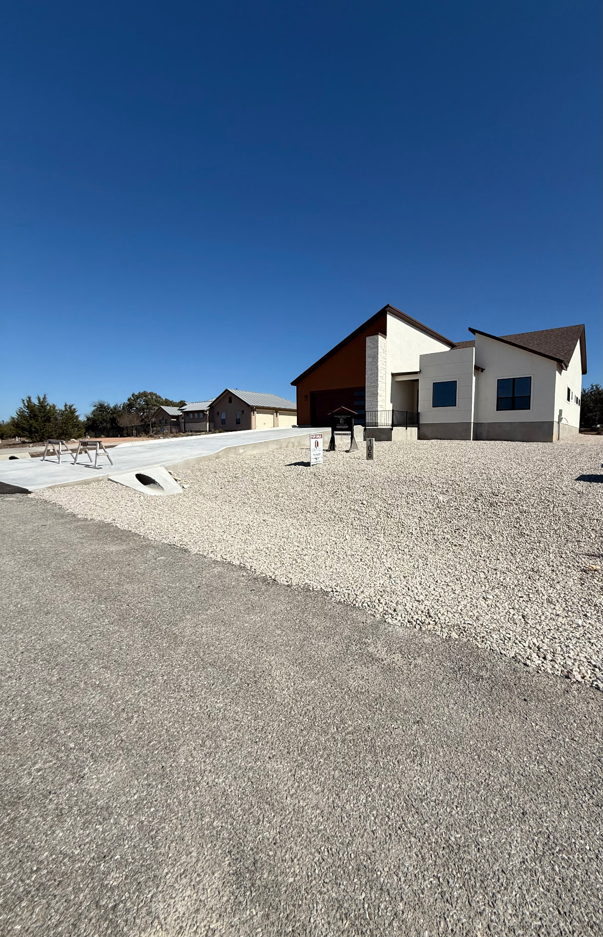 Crushed stone front yard with concrete drive and culvert at new build home